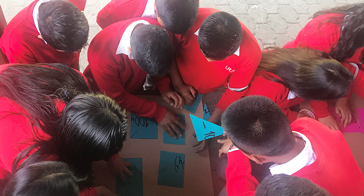 Students gathered in a circle working on a poster board